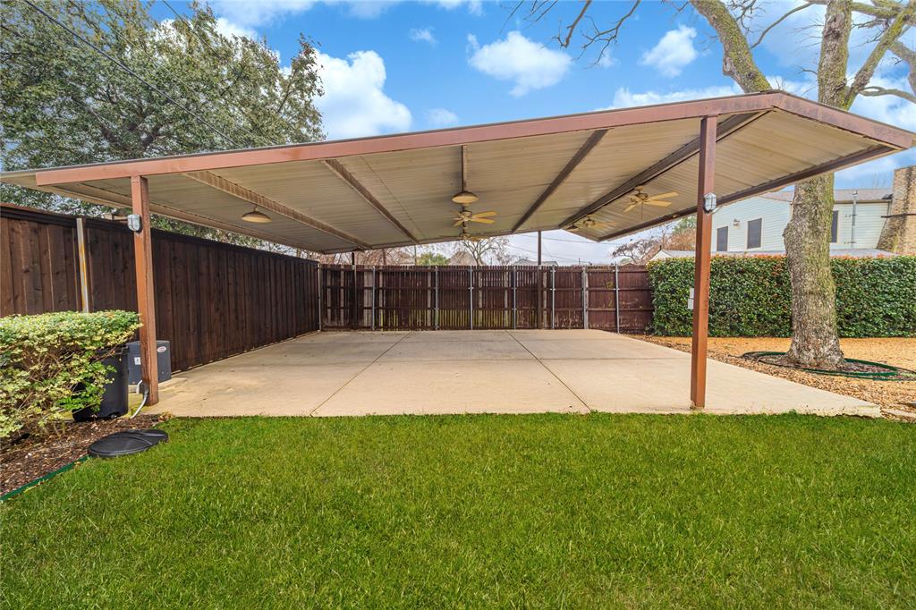 7302 Kenwell Street Dallas, TX 75209 - Photo 23 of 29 a view of a backyard with table and chairs under an umbrella