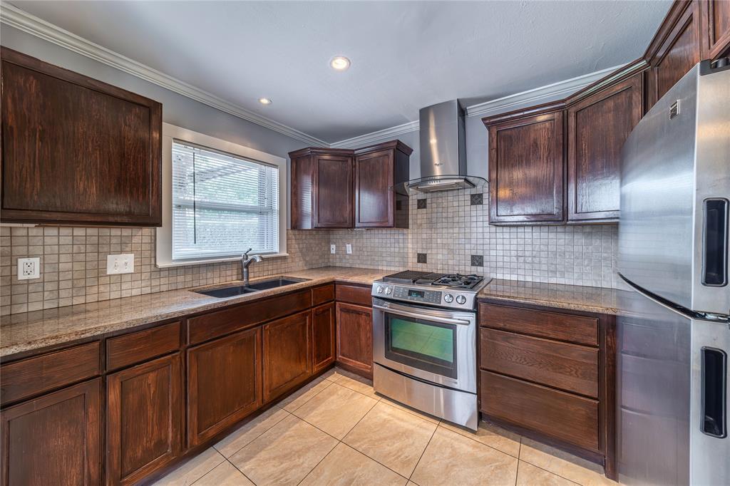 7302 Kenwell Street Dallas, TX 75209 - Photo 4 of 29 a kitchen with stainless steel appliances granite countertop wooden cabinets stove top oven and sink
