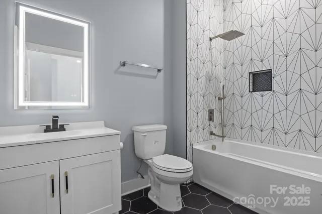 a bathroom with a toilet sink vanity tub and shower