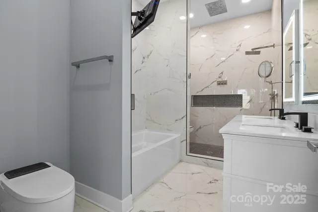 a bathroom with a sink a toilet and shower