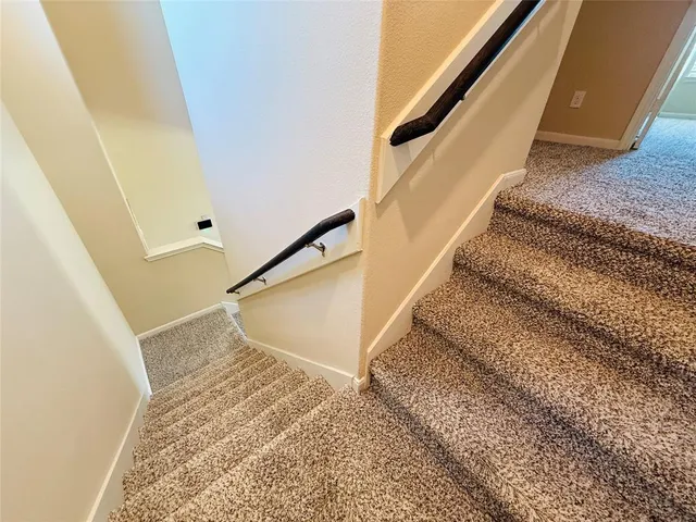 a view of staircase with white walls and railing