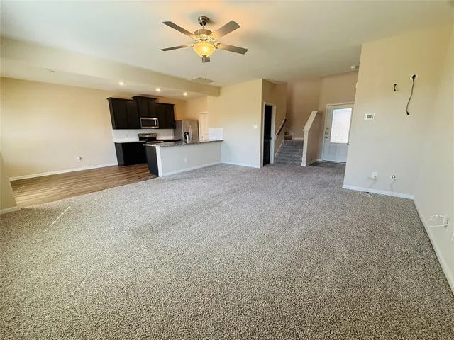 a view of empty room with a kitchen