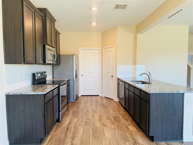 a kitchen with granite countertop a sink and wooden cabinets