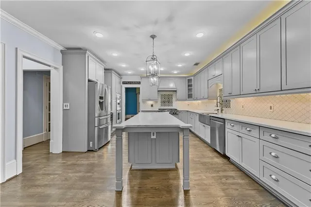a kitchen with a sink stainless steel appliances cabinets and a window