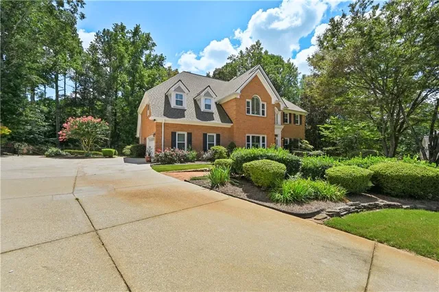 a front view of a house with a yard and potted plants