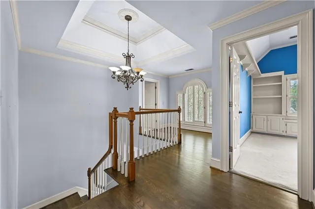 a view of a hallway with wooden floor and staircase