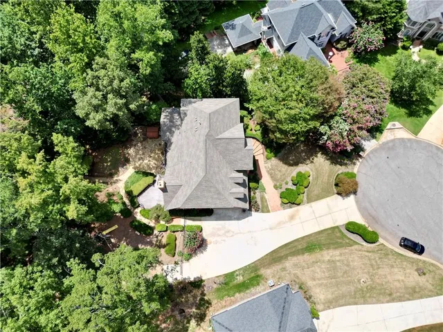 an aerial view of a house with yard and trees