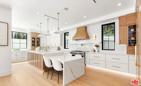 a kitchen with a sink a counter top space and living room view
