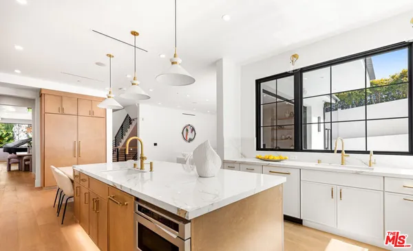a kitchen with a sink dishwasher and a stove with wooden floor