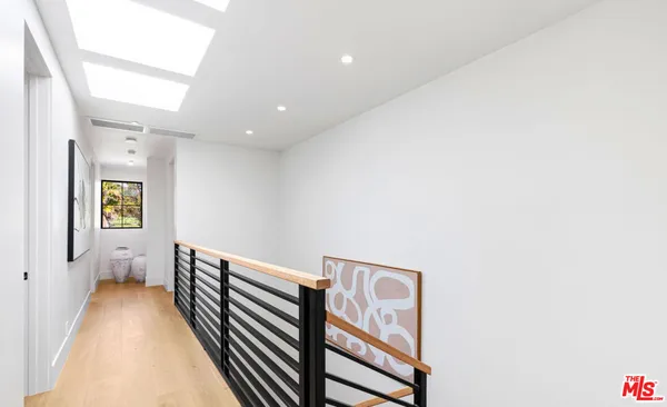 a bedroom with a bed and dresser next to a window