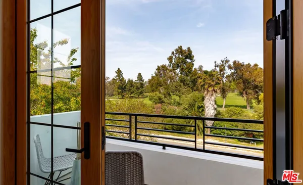 a view of a hallway with wooden floor and furniture