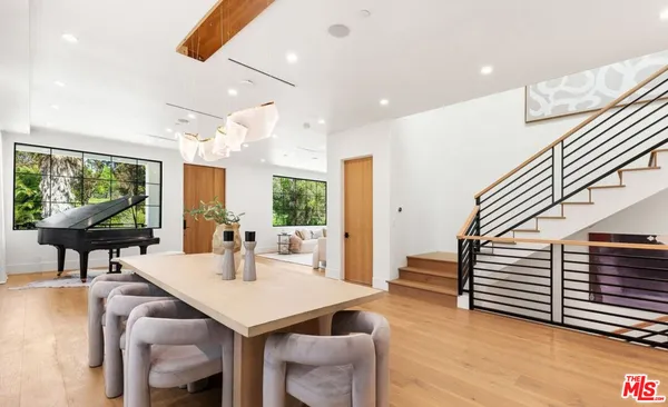 a dining hall with stainless steel appliances kitchen island granite countertop a sink and a couch