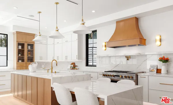 a kitchen with a table chairs stove and wooden floor