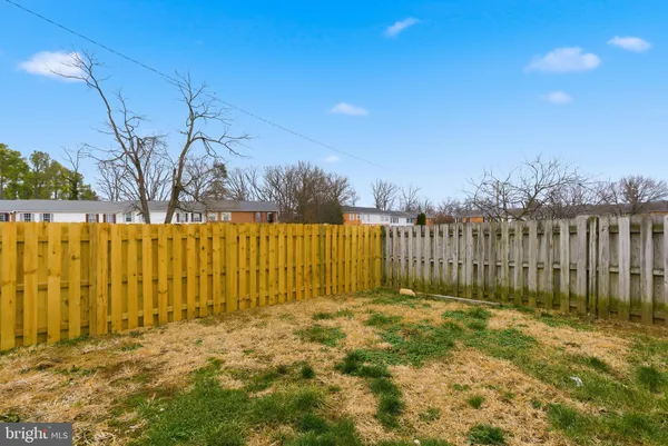 a view of backyard with wooden fence