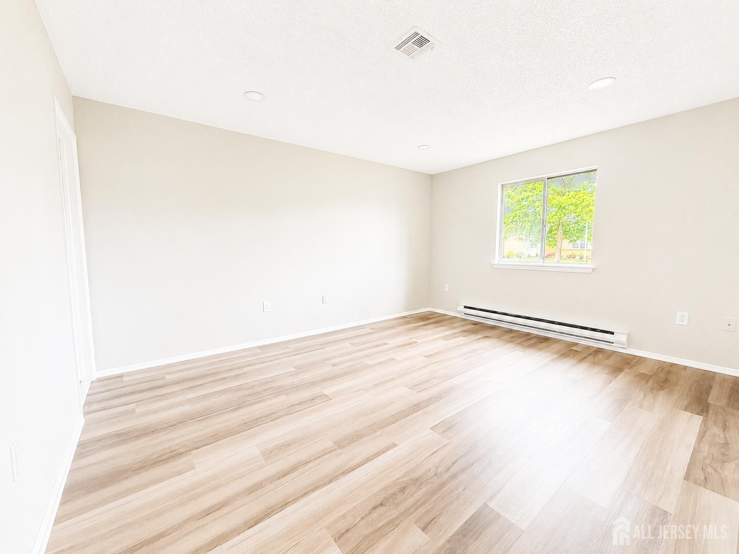 621 A Deal Road Monroe Township, NJ 08831 - Photo 19 of 27 an empty room with wooden floor and windows