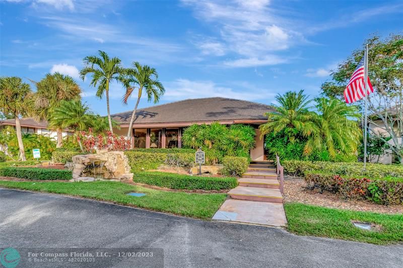 9268 Sable Ridge Circle, Unit C Boca Raton, FL 33428 - Photo 49 of 50 a front view of a house with a yard and fountain in middle