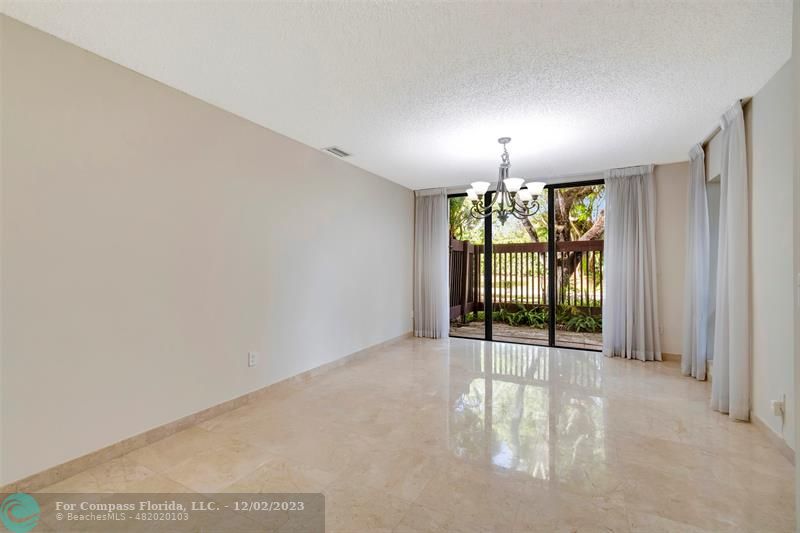 9268 Sable Ridge Circle, Unit C Boca Raton, FL 33428 - Photo 10 of 50 an empty room with windows and chandelier