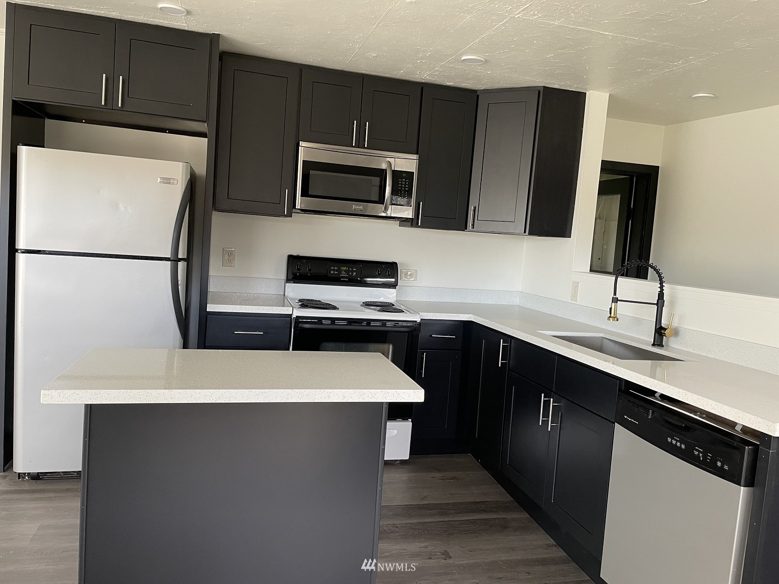 15346 Southeast May Valley Road Renton, WA 98059 - Photo 5 of 26 a kitchen with a sink a microwave a refrigerator and cabinets