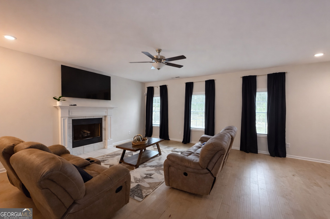 4355 Cornwall Drive Forsyth, GA 31029 - Photo 4 of 23 a living room with furniture a fireplace and a flat screen tv