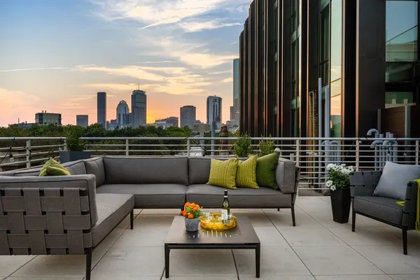a roof deck with couches and potted plants