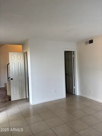 an empty room with wooden floor and bathroom