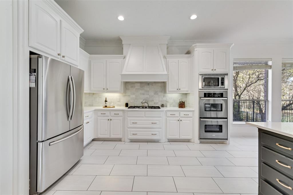 15 Falcons View Pass Heath, TX 75032 - Photo 11 of 38 a kitchen with stainless steel appliances a refrigerator sink and cabinets