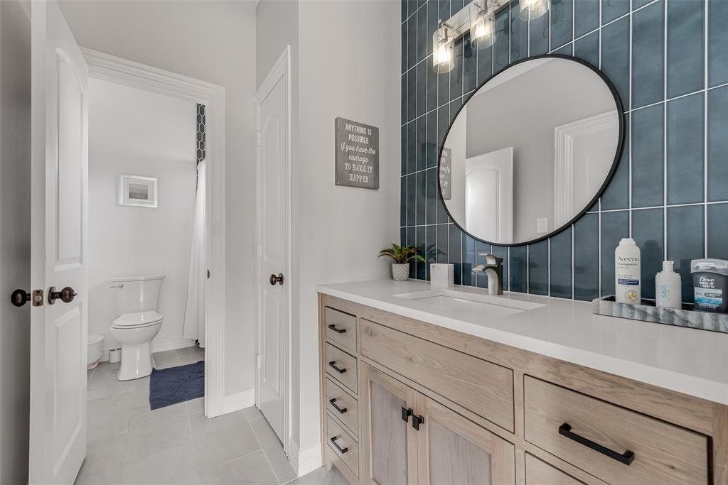 15 Falcons View Pass Heath, TX 75032 - Photo 25 of 38 a bathroom with a toilet a sink and a mirror