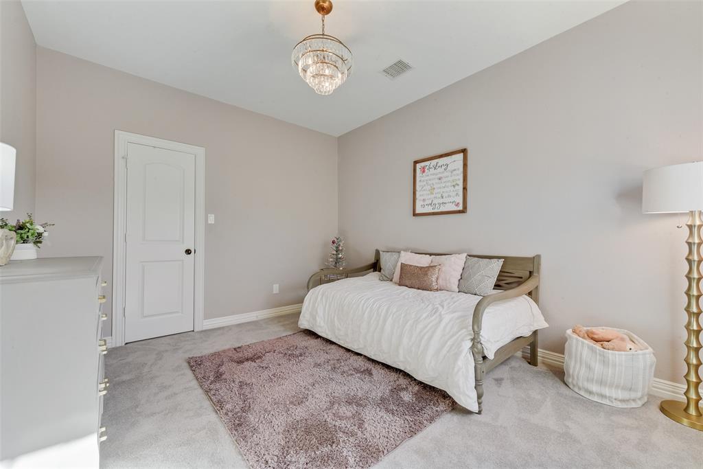 15 Falcons View Pass Heath, TX 75032 - Photo 29 of 38 a bedroom with a large bed and a chandelier