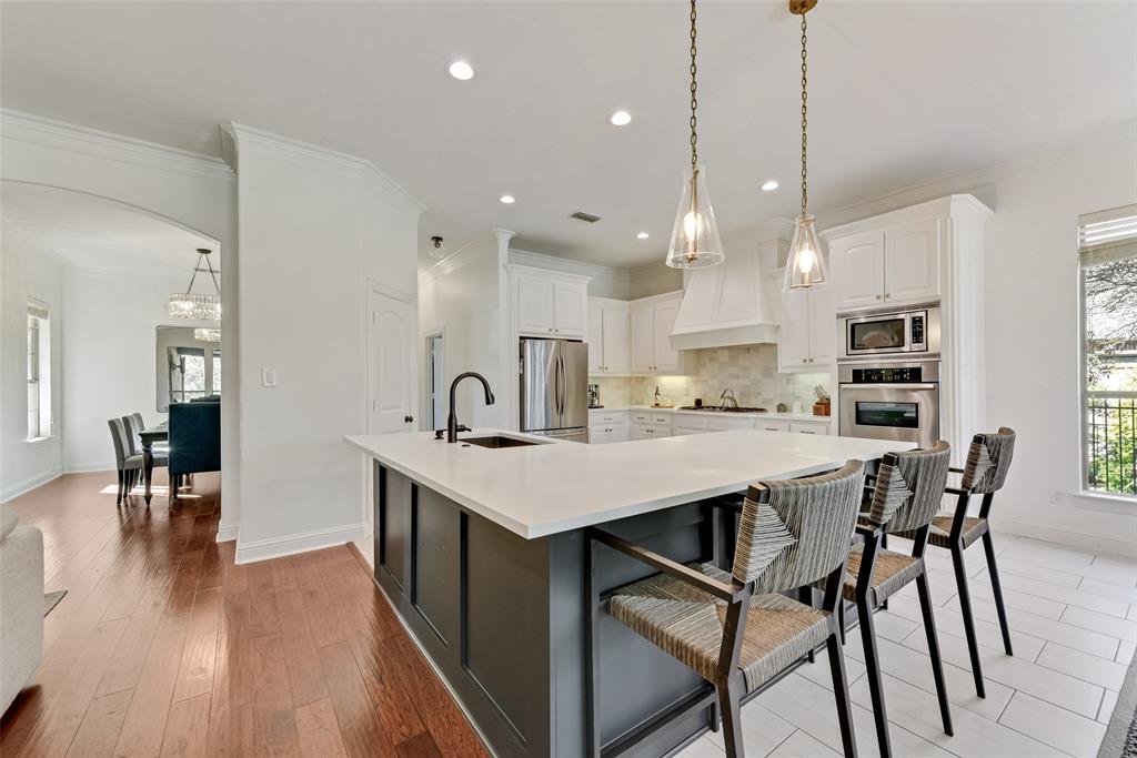 15 Falcons View Pass Heath, TX 75032 - Photo 10 of 38 a kitchen with stainless steel appliances kitchen island granite countertop a table chairs in it and white cabinets