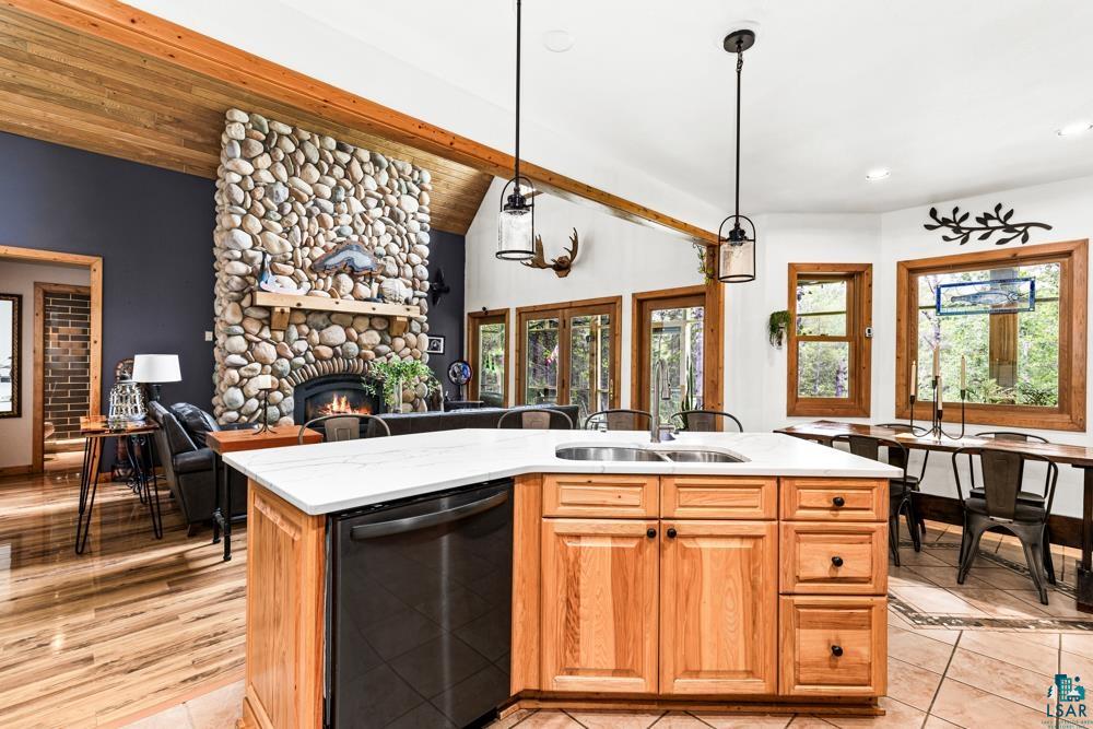 4471 South Rockmont Road South Range, WI 54874 - Photo 13 of 48 Kitchen featuring a fireplace, an island with sink, wooden ceiling, pendant lighting, and black dishwasher