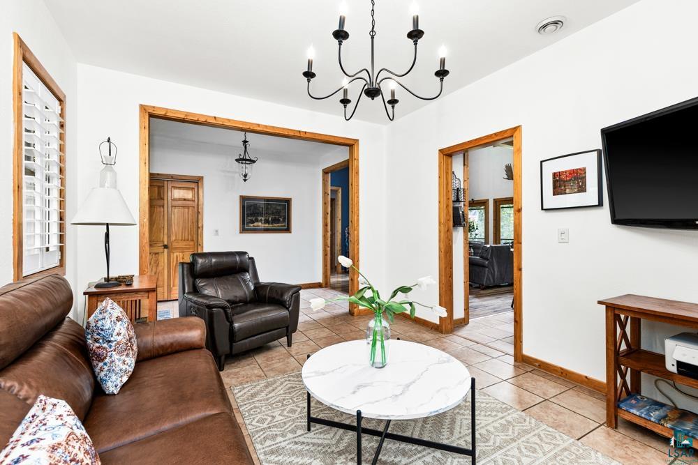 4471 South Rockmont Road South Range, WI 54874 - Photo 20 of 48 Tiled living room featuring a notable chandelier