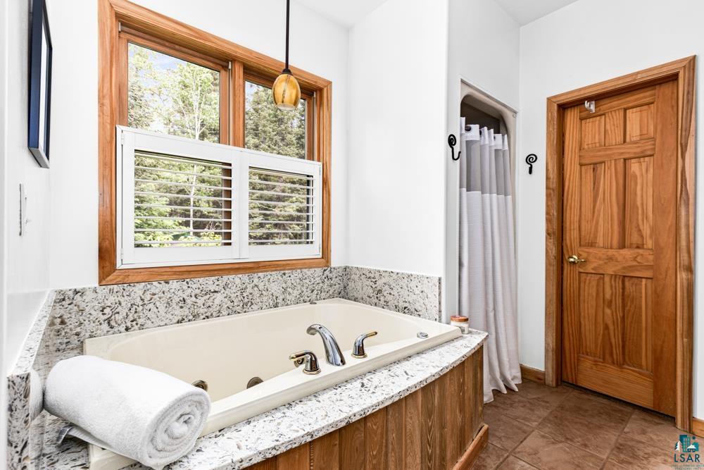 4471 South Rockmont Road South Range, WI 54874 - Photo 25 of 48 Bathroom featuring a healthy amount of sunlight, tile floors, and a bathtub