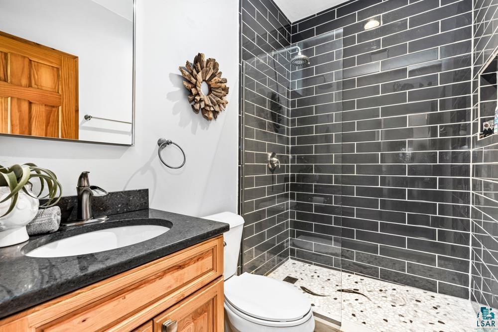 4471 South Rockmont Road South Range, WI 54874 - Photo 29 of 48 Bathroom featuring tiled shower, toilet, and vanity with extensive cabinet space