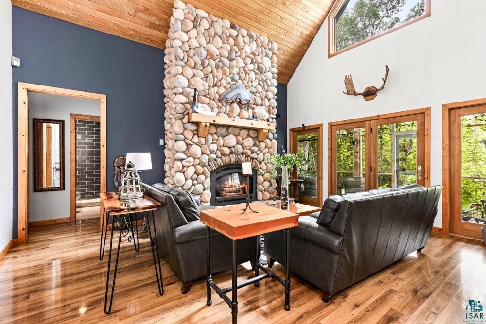 4471 South Rockmont Road South Range, WI 54874 - Photo 7 of 48 Living room featuring a stone fireplace, high vaulted ceiling, wood ceiling, and light hardwood / wood-style flooring
