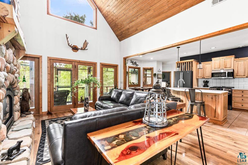 4471 South Rockmont Road South Range, WI 54874 - Photo 8 of 48 Tiled living room with a stone fireplace, high vaulted ceiling, french doors, and wood ceiling