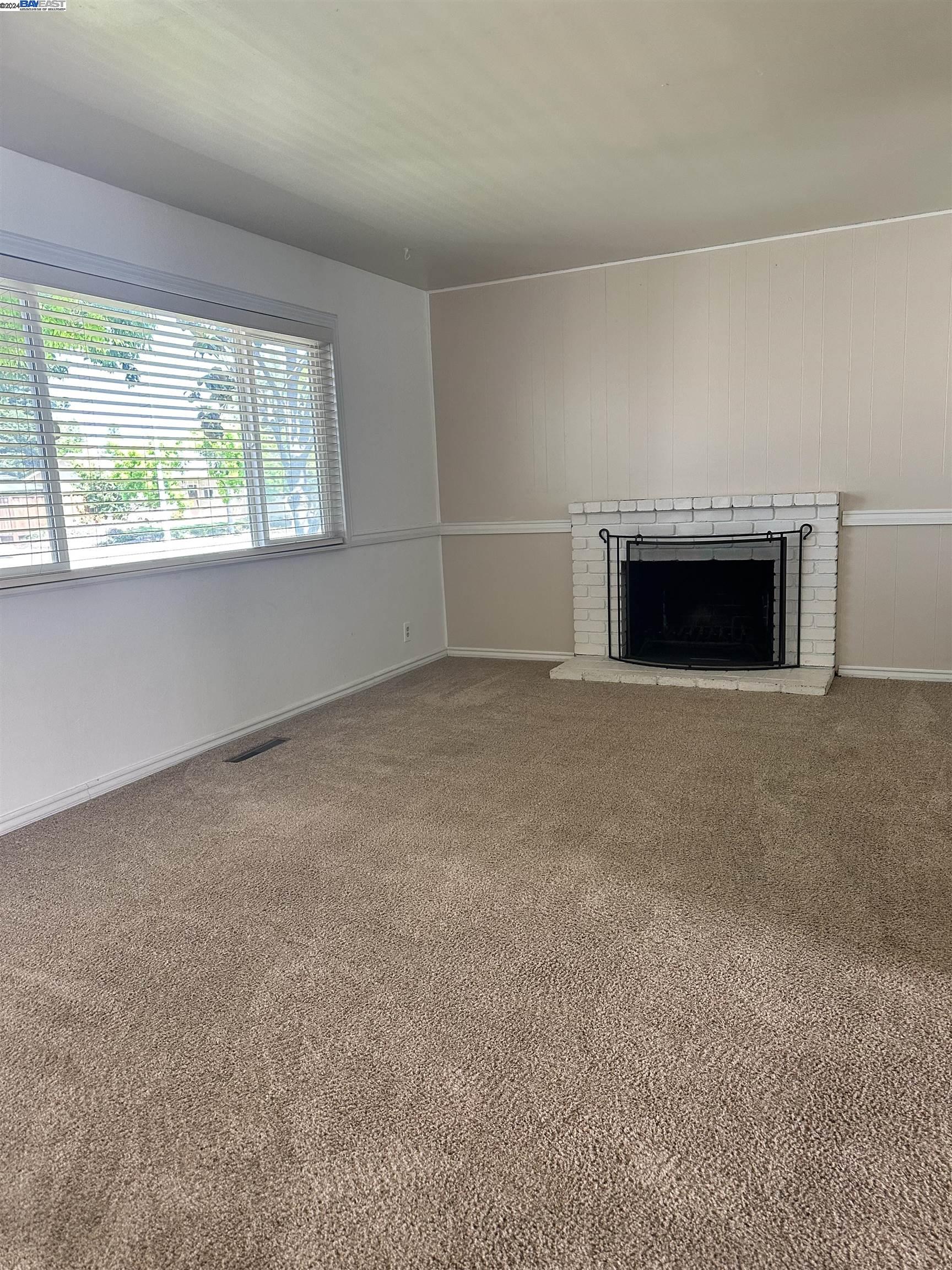 Carlton Square Livermore, CA 94550 - Photo 6 of 25 a view of empty room with a fireplace and large window