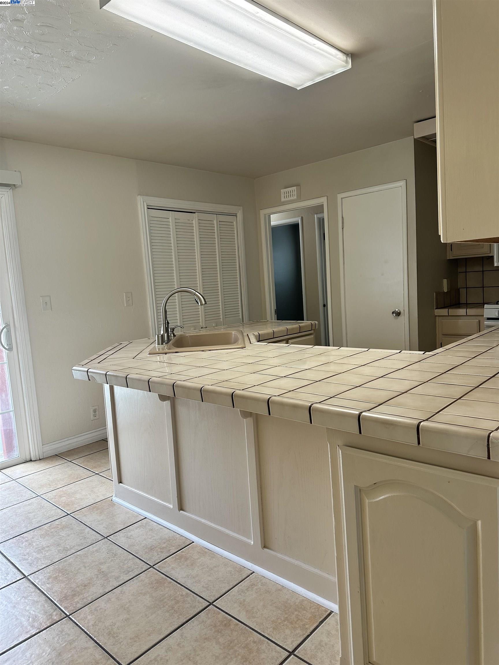 Carlton Square Livermore, CA 94550 - Photo 9 of 25 a room with kitchen island a sink a stove a refrigerator and black cabinets