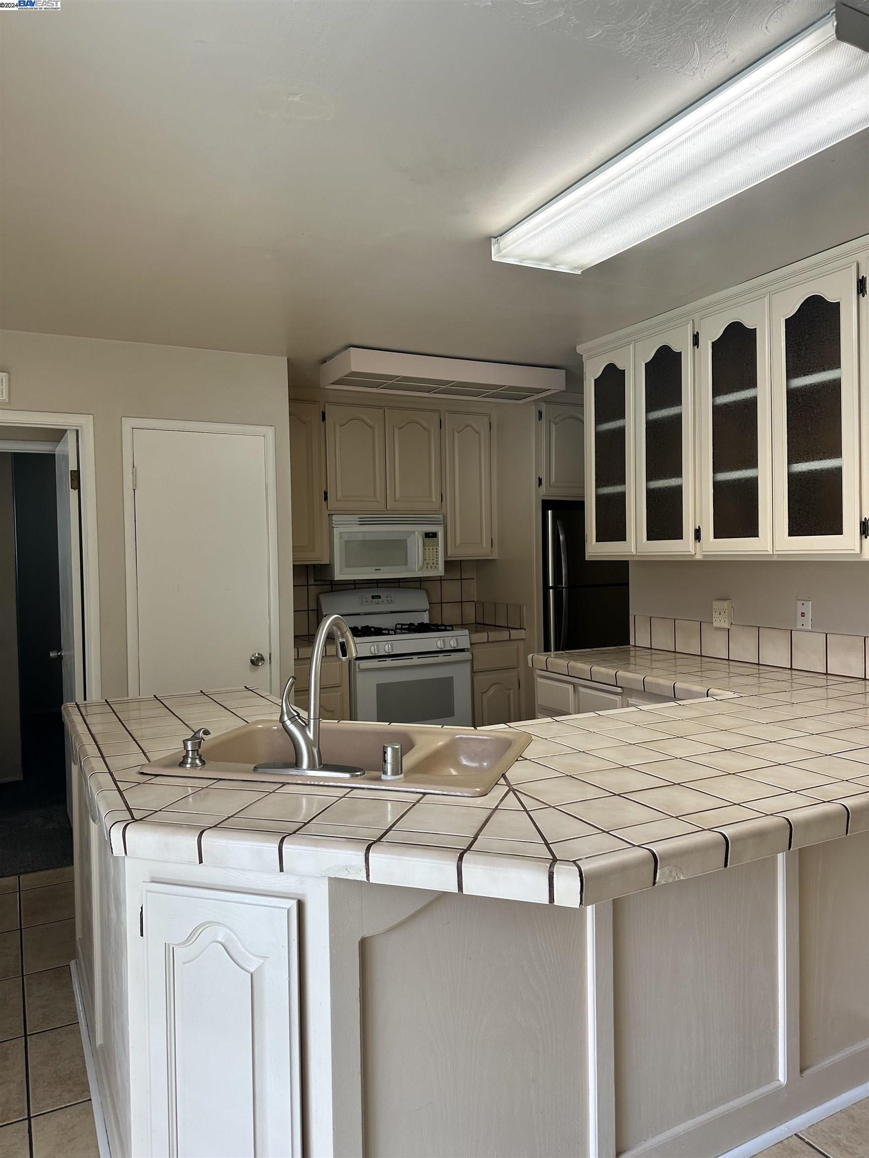 Carlton Square Livermore, CA 94550 - Photo 10 of 25 a kitchen that has a sink and a stove in it
