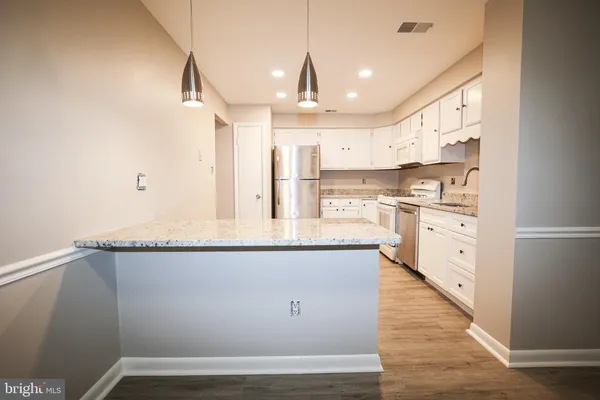 a kitchen with stainless steel appliances granite countertop a sink a stove and a refrigerator