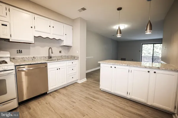 a kitchen with cabinets and wooden floor