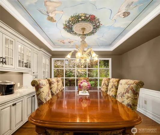 a view of a dining room with furniture a chandelier and a large window