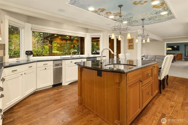 a kitchen with granite countertop a sink cabinets and wooden floor