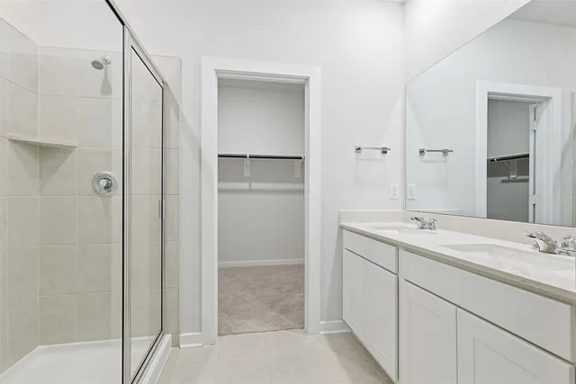 a bathroom with a double vanity sink mirror and shower