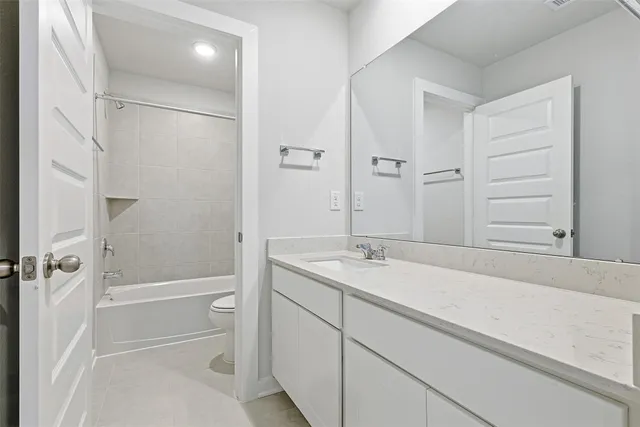 a bathroom with a granite countertop sink a toilet and shower