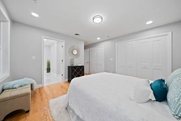 a bathroom with a granite countertop sink toilet a large mirror and a window
