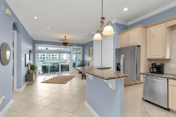 a kitchen with stainless steel appliances granite countertop a refrigerator a sink and white cabinets