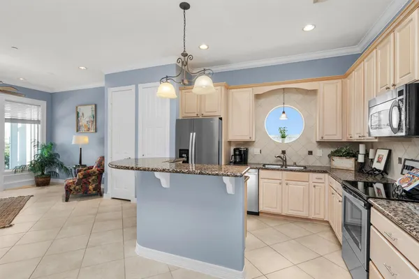 a kitchen with stainless steel appliances granite countertop a sink a stove top oven a counter space and cabinets