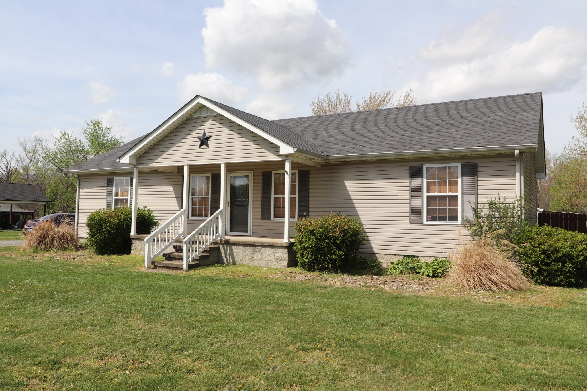 353 Stevens Circle Lafayette, TN 37083 - Photo 2 of 25 a front view of a house with a garden and porch