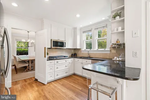 a bathroom with a granite countertop sink mirror and toilet