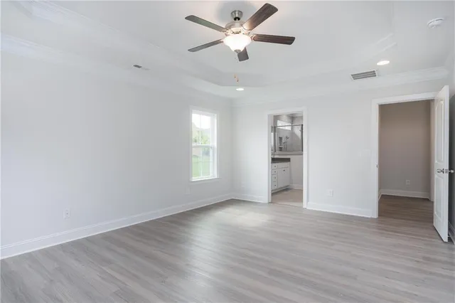 a view of an empty room with window and wooden floor